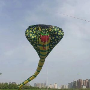 A green and black cobra-shaped kite with a flared hood.