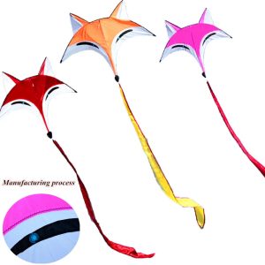 Three star-shaped kites in red, orange and pink with long ribbon tails.